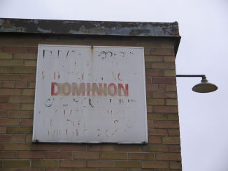 [Decades-old Dominion sign still clinging to the wall of what was once a store]